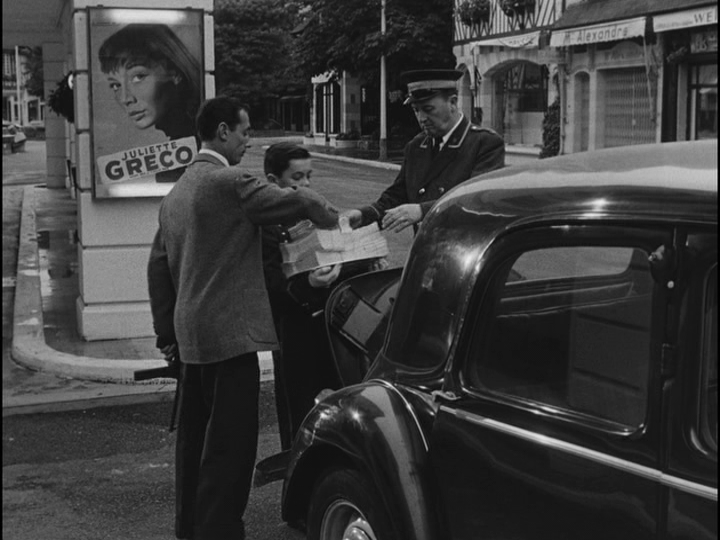 The police help one of the bellhops load the money he is carrying into the trunk of a police car