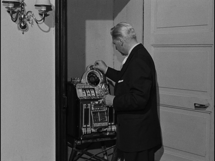 Bob pulling the lever on the slot machine he keeps in a closet