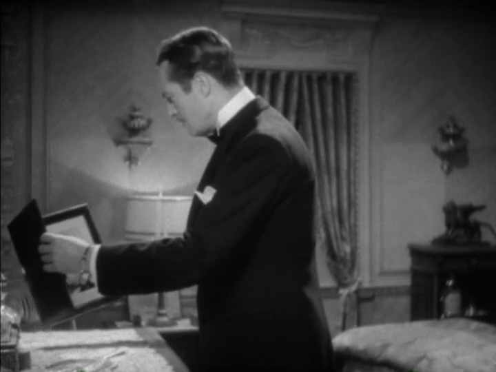 Medium shot of Dugan picking up the photos