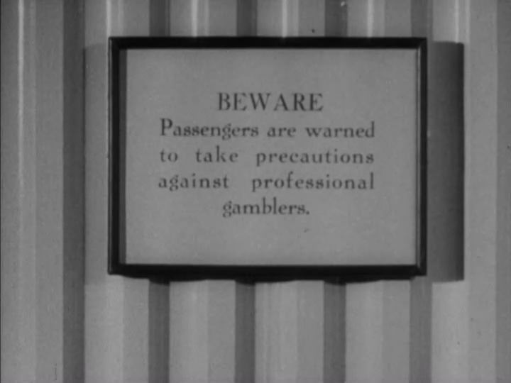 Close-up of a sign that reads "Beware: Passengers are warned to take precautions against professional gamblers"