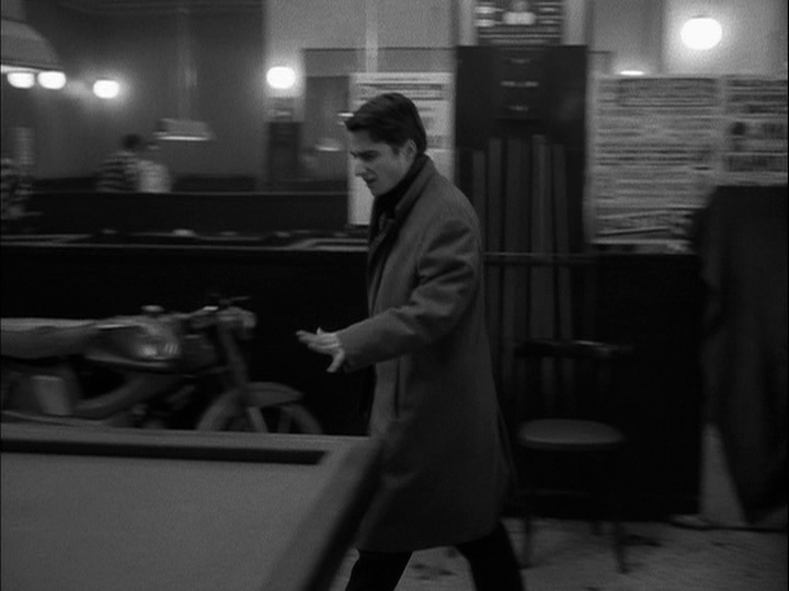 Medium long shot of Paul gesturing with his arm to indicate that the room he and Madeleine have repaired to still isn't right