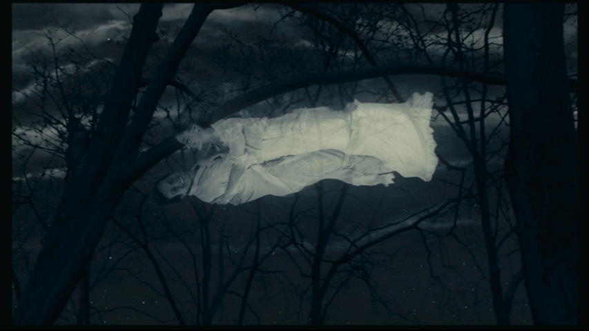 Isaac, still embracing Angelica and now vertical, smiles at the camera