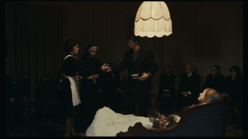 Medium shot of Isaac accepting a lightbulb from Angelica's sister and their maid