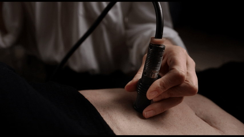 Close up of Caprice's hand as she tattoos Saul's new organ