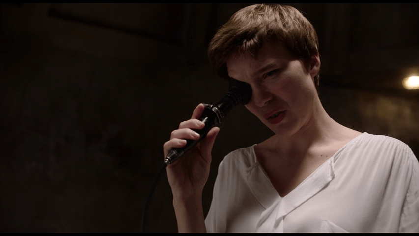 Medium shot of Clarice looking through an eyepiece