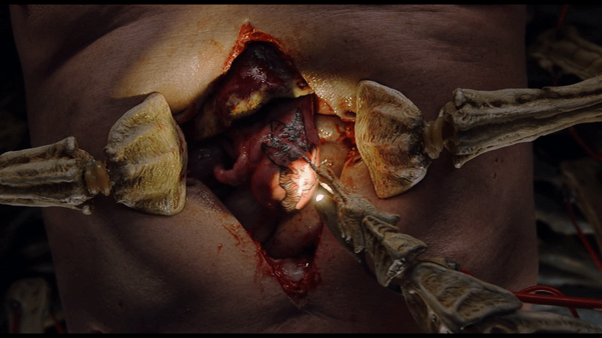 Close up of the Sark removing Saul's tattooed new organ