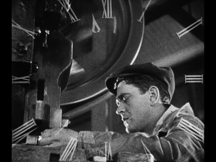 Medium shot of Jim at work at a punch press with a clock face superimposed over him