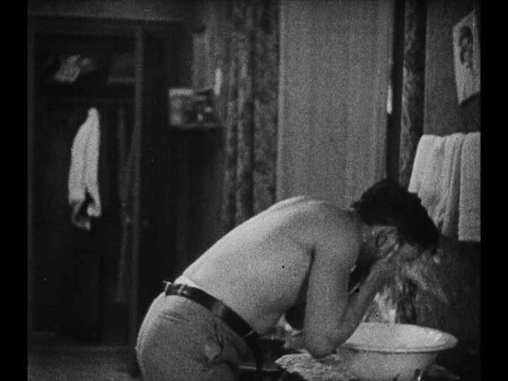 Medium shot of Jim washing his face in a basin