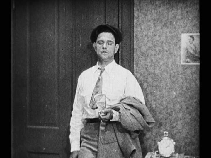 Medium long shot of Jim leaning against his doorway