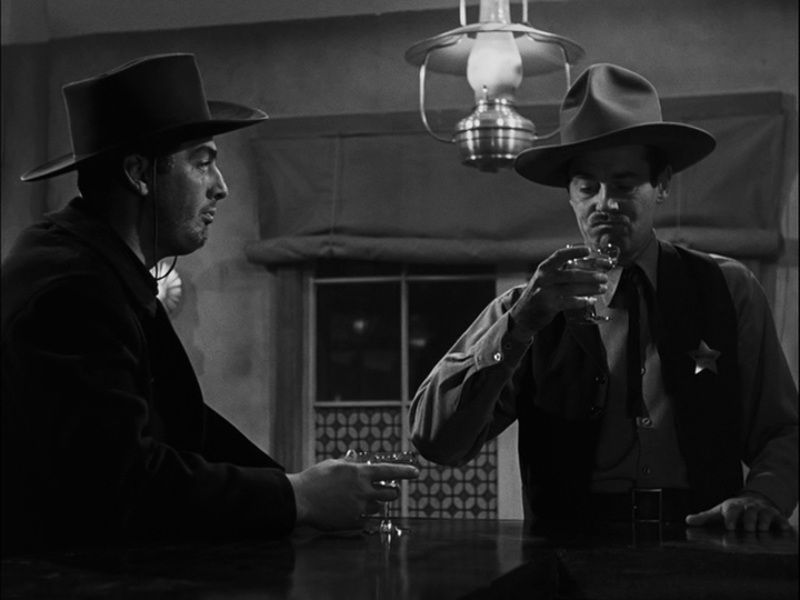 In a continuation of the previous shot, Earp looks at his drink...