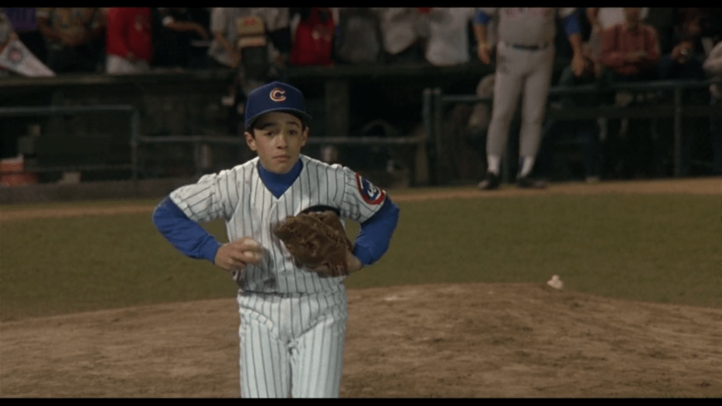 Medium shot of Henry taunting a baserunner by pantomiming a chicken