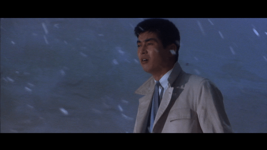 Medium shot of Tetsu in a snow flurry, still singing