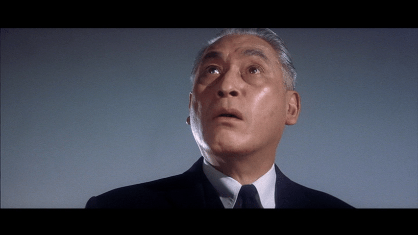 Close-up of Kurata looking offscreen up and to the left