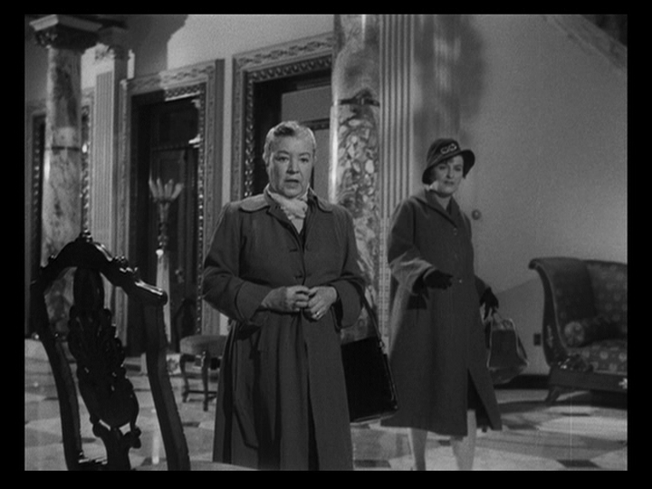 Long shot of two maids stopping in their tracks at the sight of the Nobiles and the guests arriving