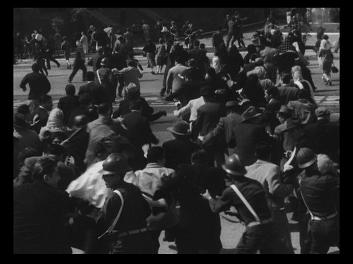 Long shot of armed police or military officials attacking a crowd