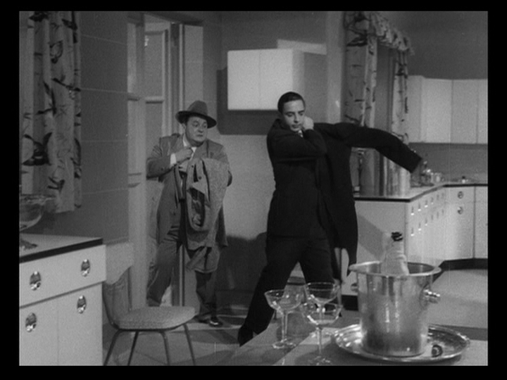 Long shot of two more servants putting on their coats and departing