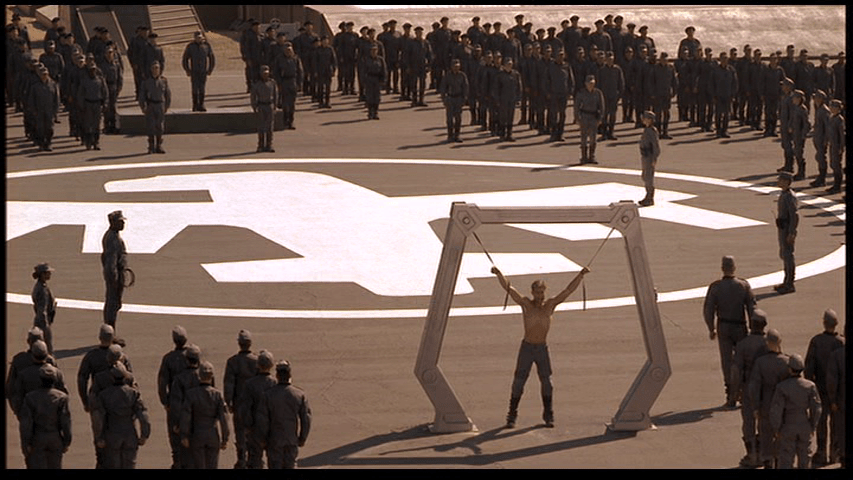 Extreme long shot of Johnny awaiting his punishment of flogging as his fellow soldiers watch