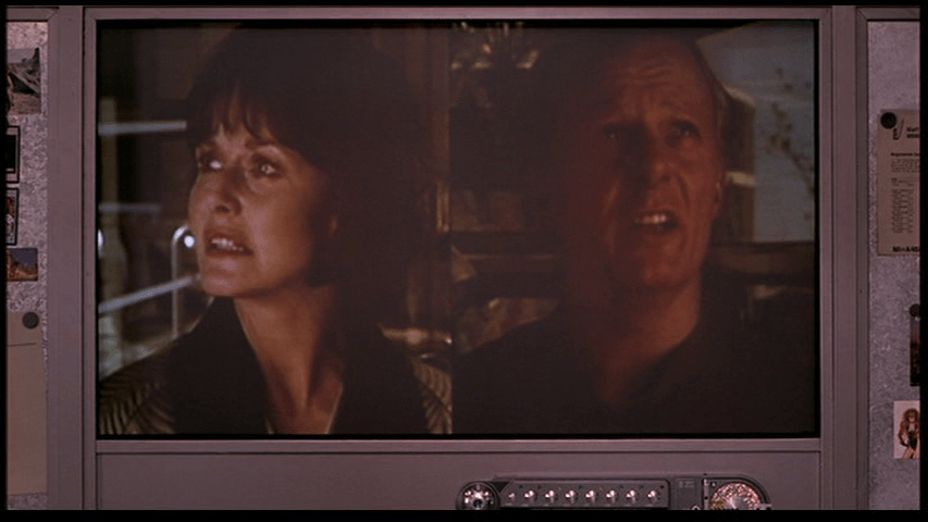 Close-up of a console displaying a split screen image of Johnny's parents talking to him via videophone about how it suddenly has gotten dark