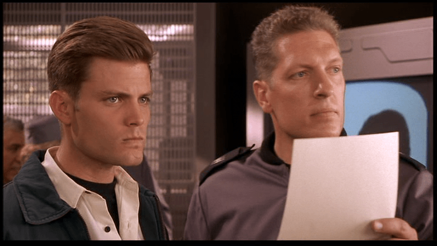 Medium shot of Johnny standing next to Sgt. Zim, who holds a piece of paper