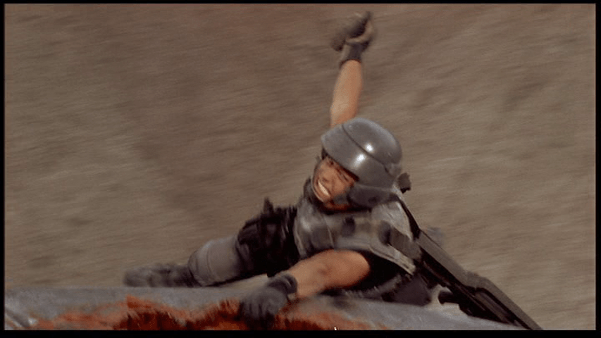 Johnny brandishes a grenade as he hangs onto the Tanker Bug for dear life