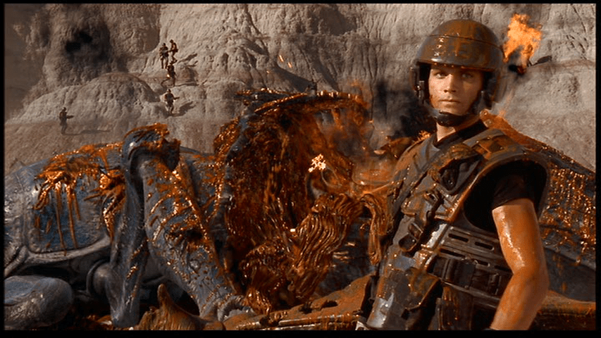 Johnny stands in front of his fallen foe, covered in its blood