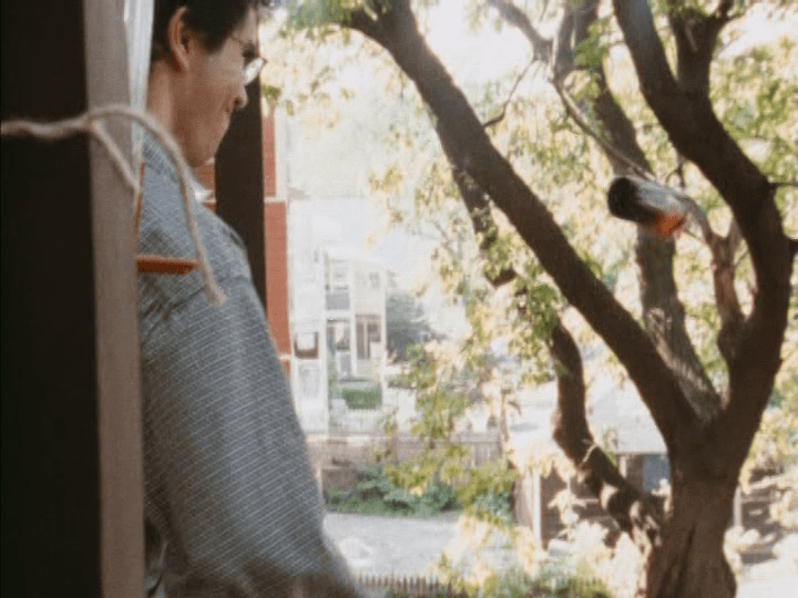 Continuation of the previous shot: the bottle of beer is suspended in mid-air after Mitchell tosses it over the balcony