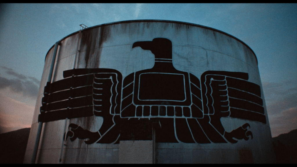 Close-up of a water tower upon which a black falcon has been painted