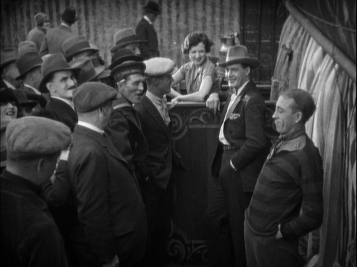 Long shot of Corby chucklingly acknowledging the challenge as the crowd laughs