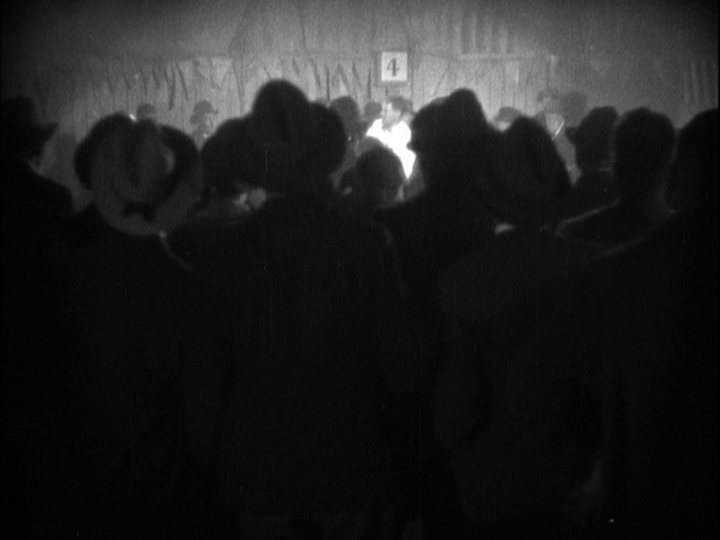 Long shot of Corby barely visible through a crowd of onlookers who dominated the bottom 3/4 of the frame