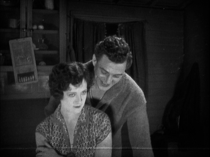 Medium shot of Sander reaching past Mabel to pick up a playing card