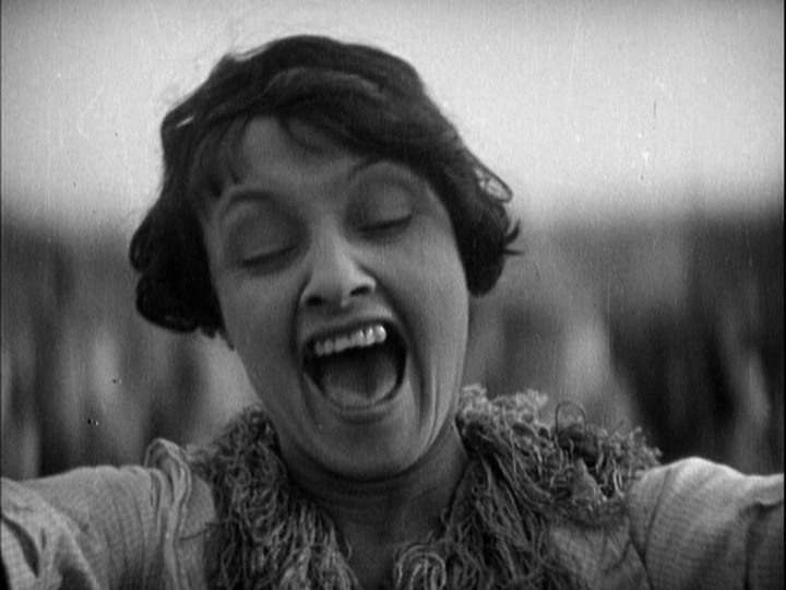 Close-up of a woman screaming as she swings back and forth on the ride