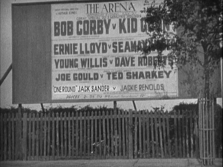Summer scene of a billboard advertising upcoming fights; Jack Sander's name is in the smallest font size