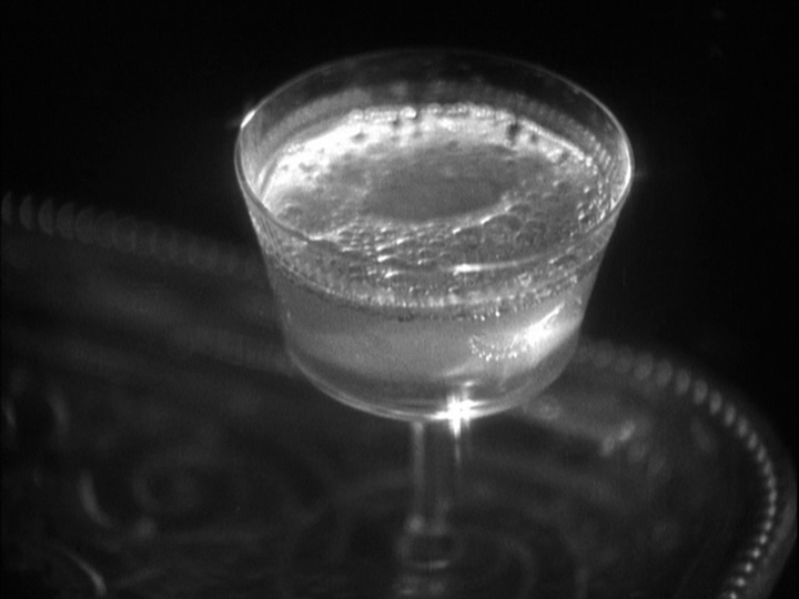 Close-up of a glass champagne bubbling way, but less vigorously than in the previous shot