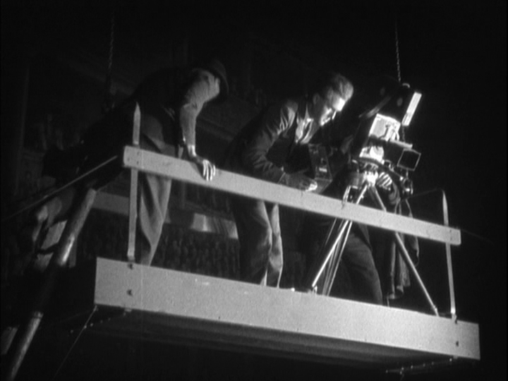 Long shot of a camera crew getting ready to cover the fight