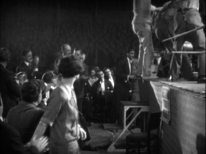 Medium long shot of Mabel rising, leaving the coat behind