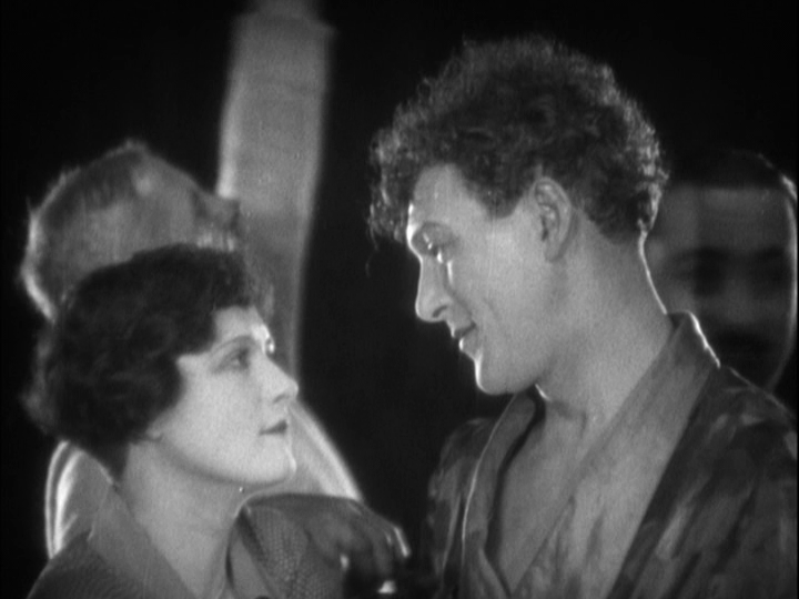 Soft-focus medium shot of Mabel and Sander looking at each other tenderly