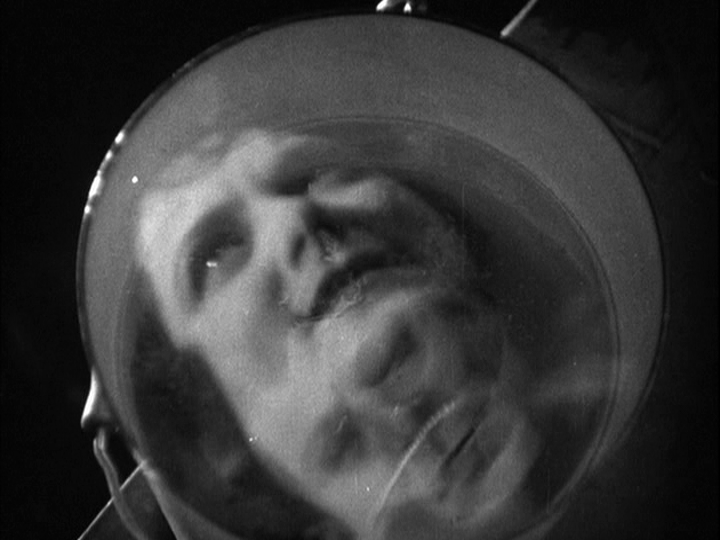 Overhead point-of-view close-up from Sander's perspective of Mabel's face reflected in the rippling water of a bucket