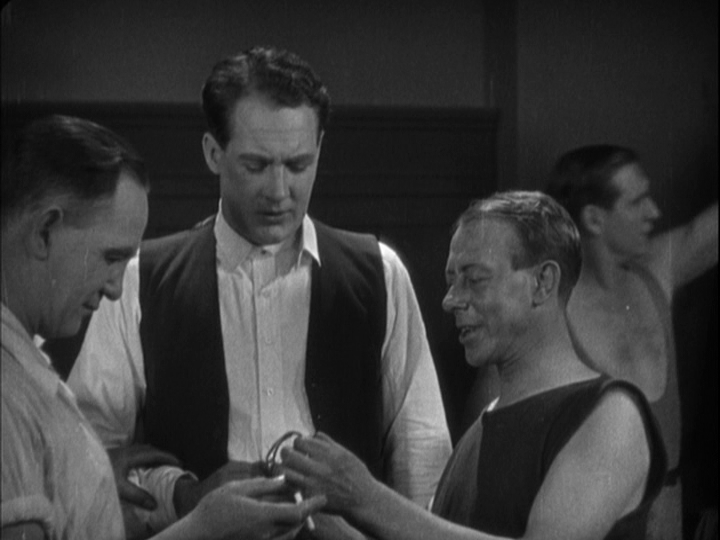 Medium shot of Corby contemplating the armlet that a member of his team has found