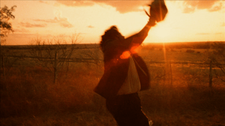 Continuation of the previous shot: the chain saw is now held high in the air