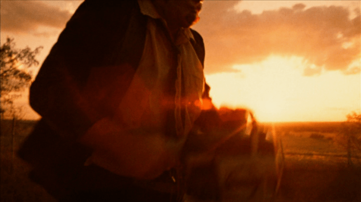 Continuation of the previous shot: the camera has moved closer and we now see just the man's torso in medium close-up