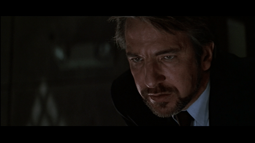 Close-up of Hans Gruber intently watching a monitor showing the FBI at work