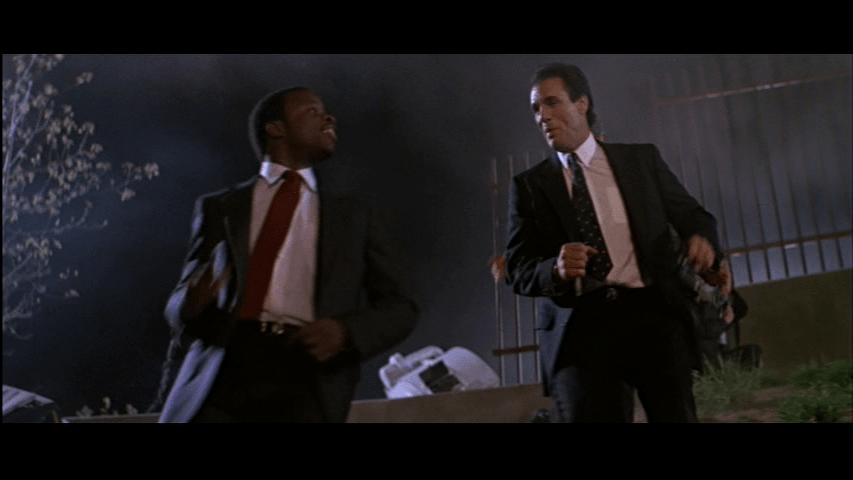 Medium shot of Agents Johnson and Johnson talking as they trot down a hill