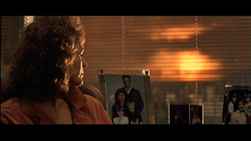 Holly, in focusin the left side of the frame, looks back at the family photo