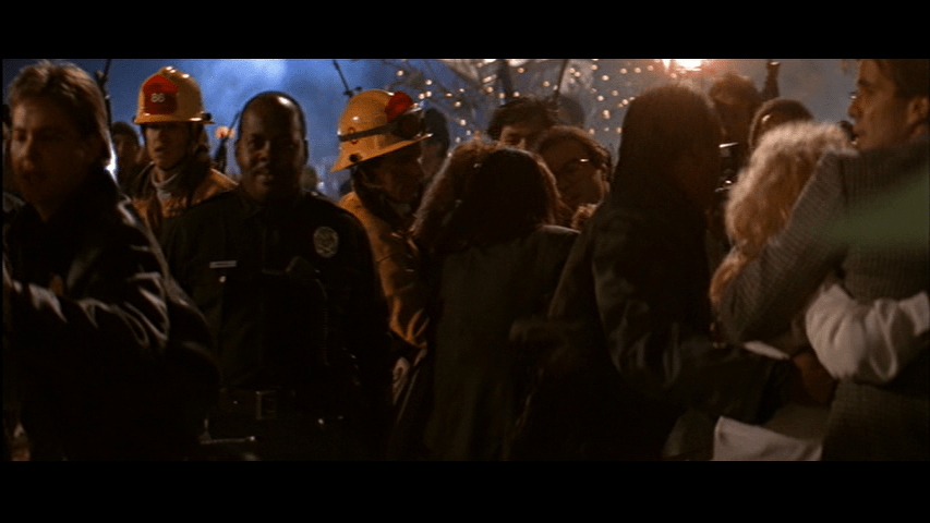 POV medium shot from McClane's perspective of Al standing in a crowd of first responders and hostages
