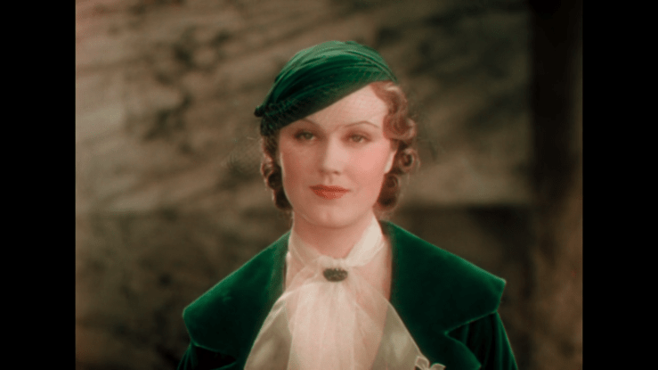 Close-up of Fay Wray in a vibrant green dress and hat