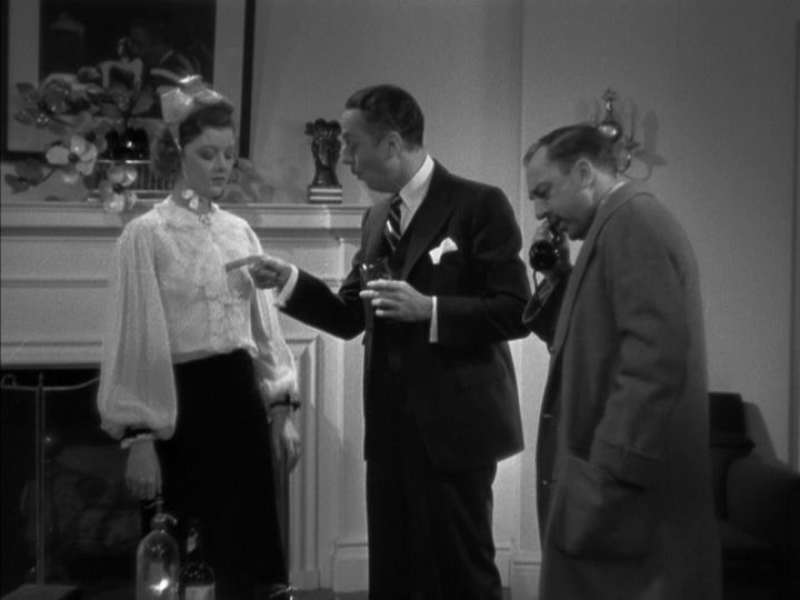 Medium long shot of Nick, who occupies the middle of the frame, putting his finger on the blouse of Nora, who occupies the left third of the frame