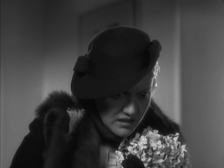 Close-up of Mimi leaning forward as she notices something