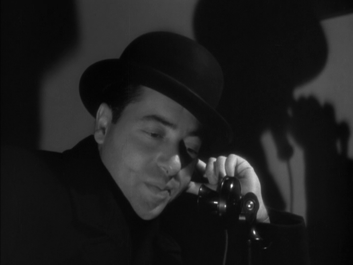 Close-up of Nunheim crouched over a phone in a composition rife with shadows