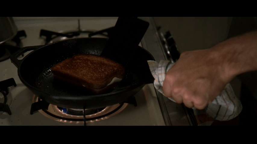 Close-up of Nate frying a grilled cheese in a cast-iron skillet