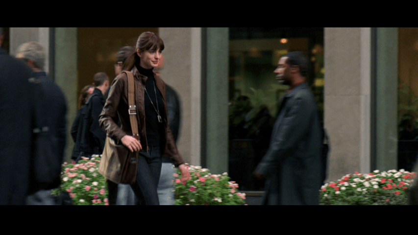 Medium long shot of Andy walking down the street in casual, but much more stylish attire than what she wore at the beginning of the film